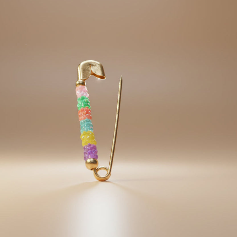 Small metallic object with colorful beads on a light gray background