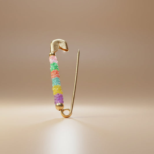 Small metallic object with colorful beads on a light gray background