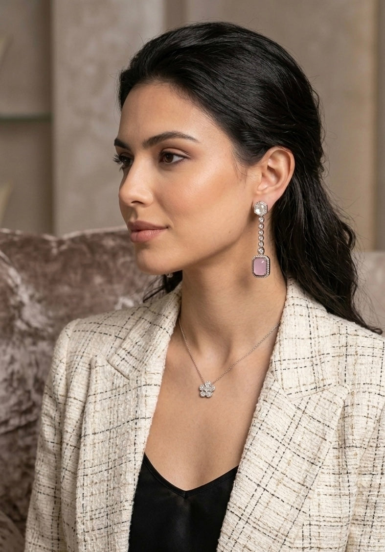 Woman wearing a checkered blazer with jewelry, including earrings and a necklace.