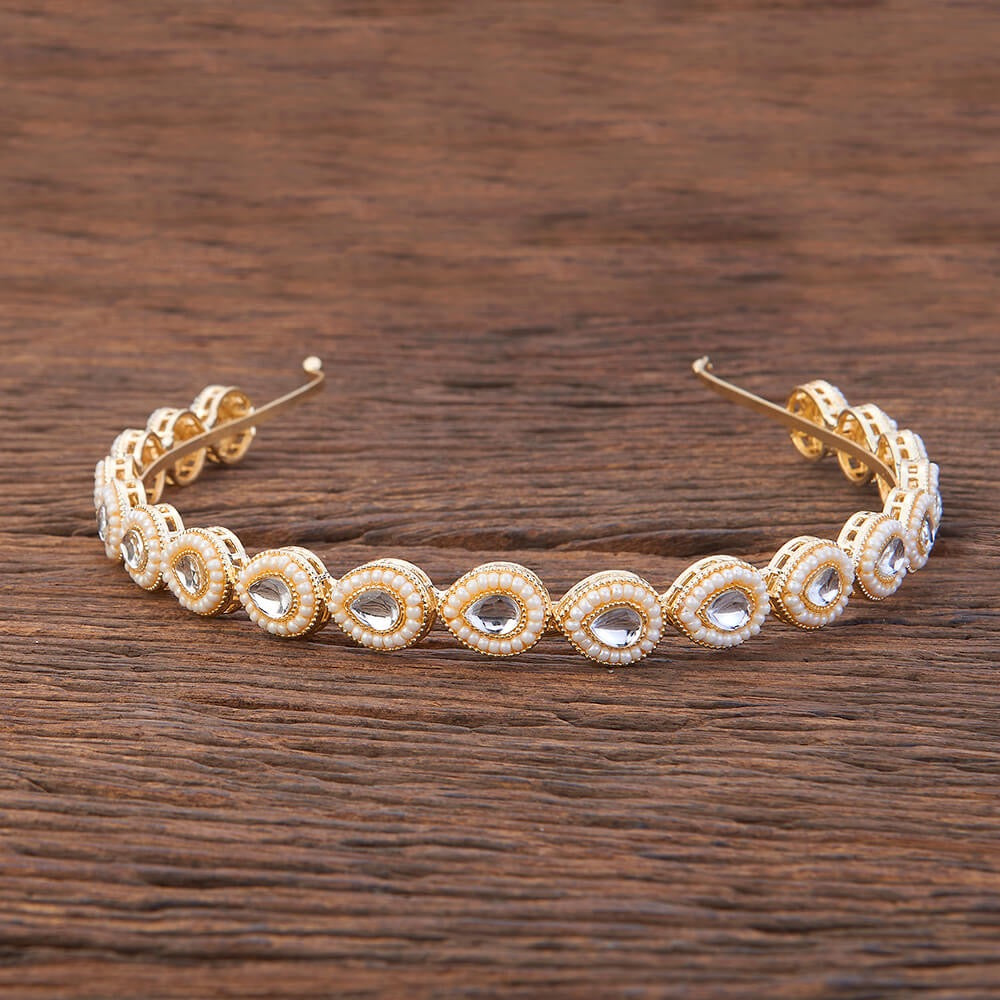 Gold and crystal headband on a wooden surface