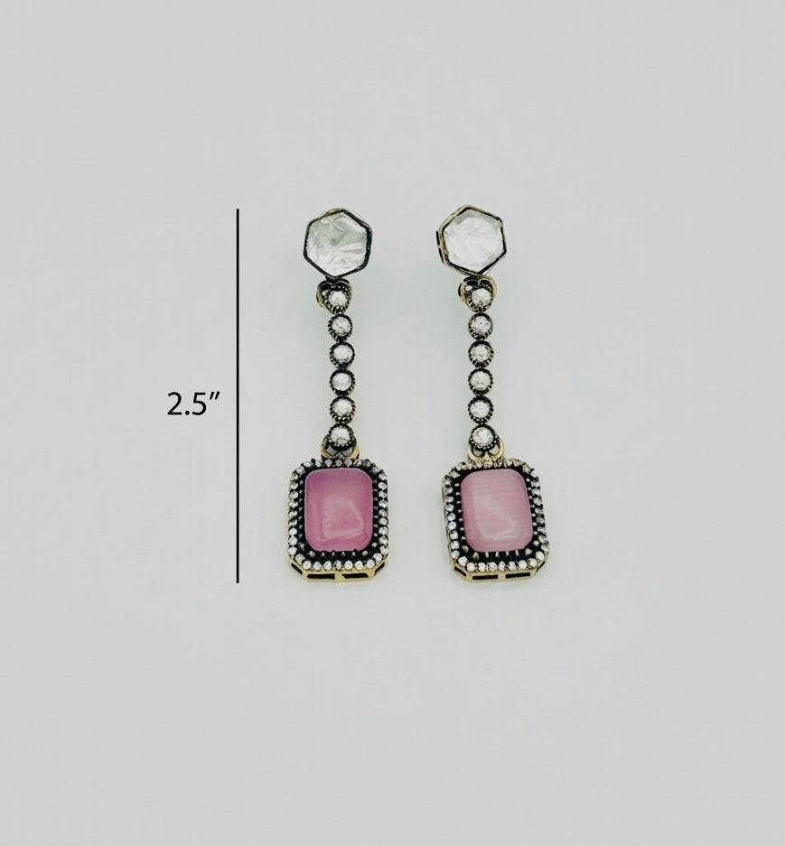 Pair of earrings with pink gemstones and silver accents on a light gray background.