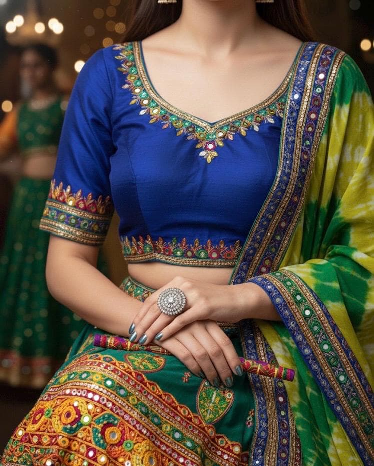 Person wearing a colorful traditional outfit with a blue blouse and green saree.
