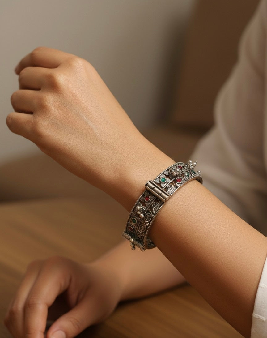 Close-up of a wrist wearing an ornate bracelet with a neutral background