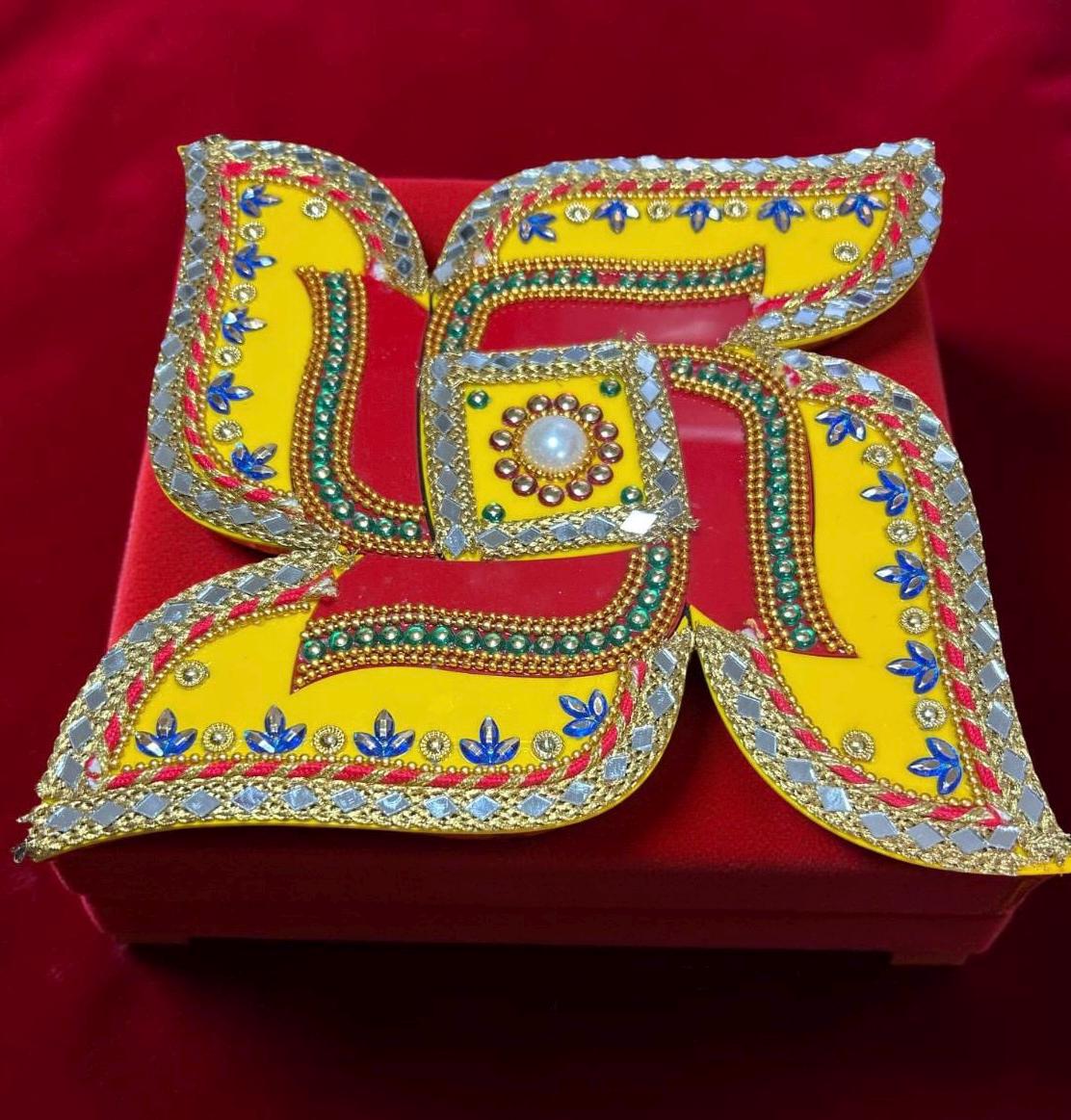 Decorative yellow swastik and multicolored design on a red background