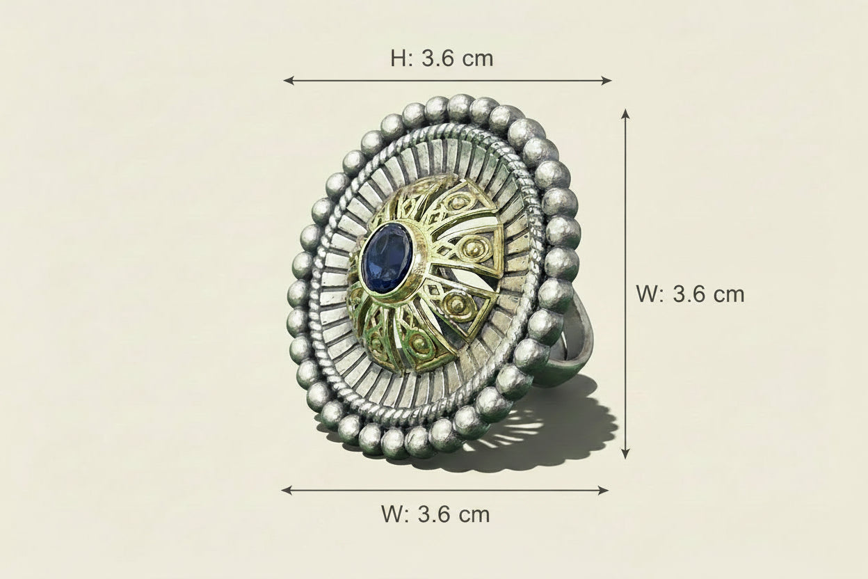 Silver ring with a decorative center on a green background