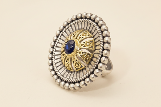 oxidized vintage style Silver ring with gold and blue gemstone on a white background