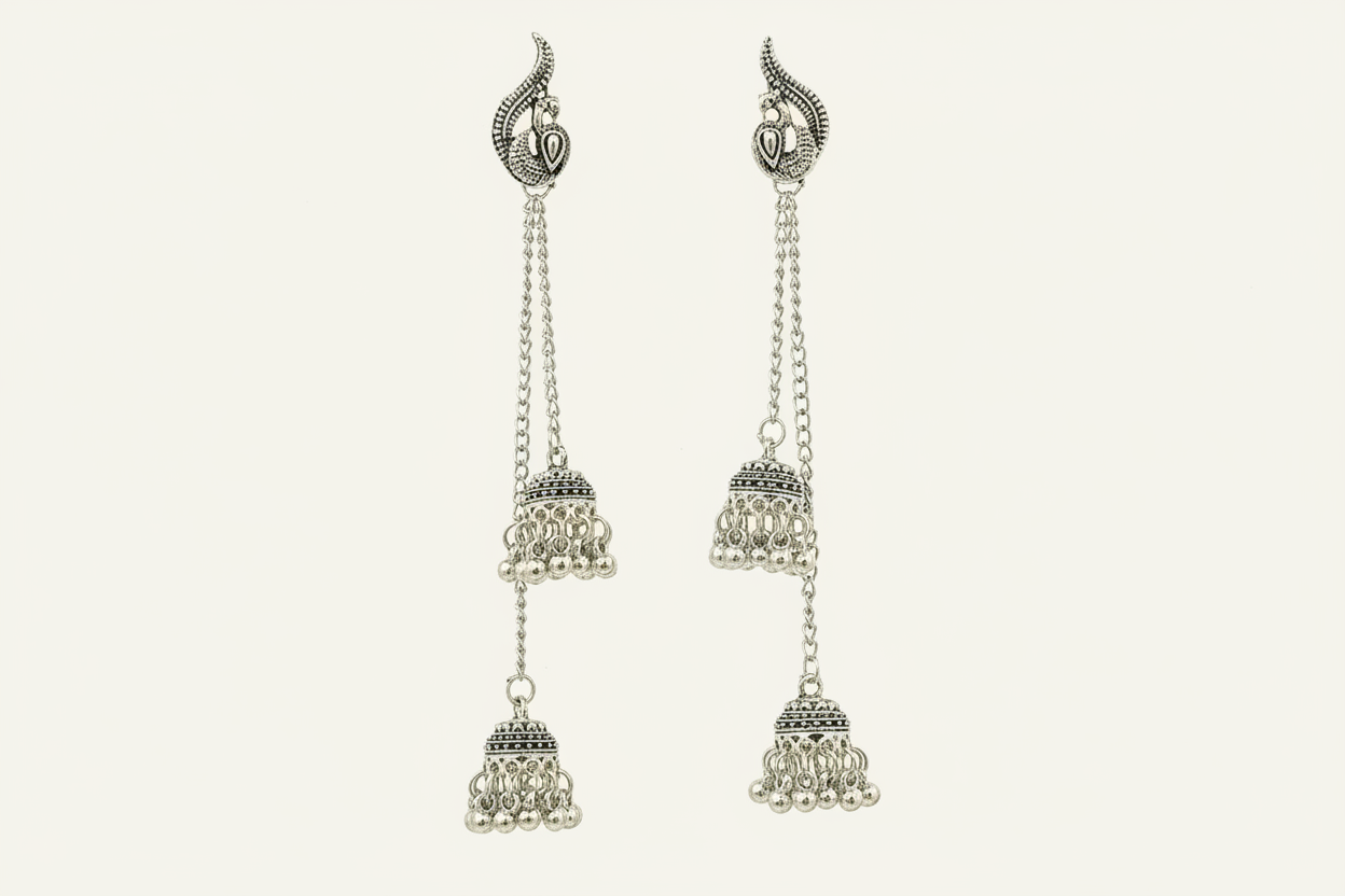 Pair of silver earrings with chain and bell-like designs on a light gray background