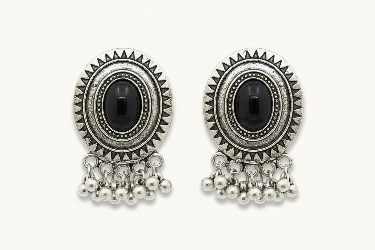 Pair of silver earrings with black gemstones and pearl-like beads on a white background
