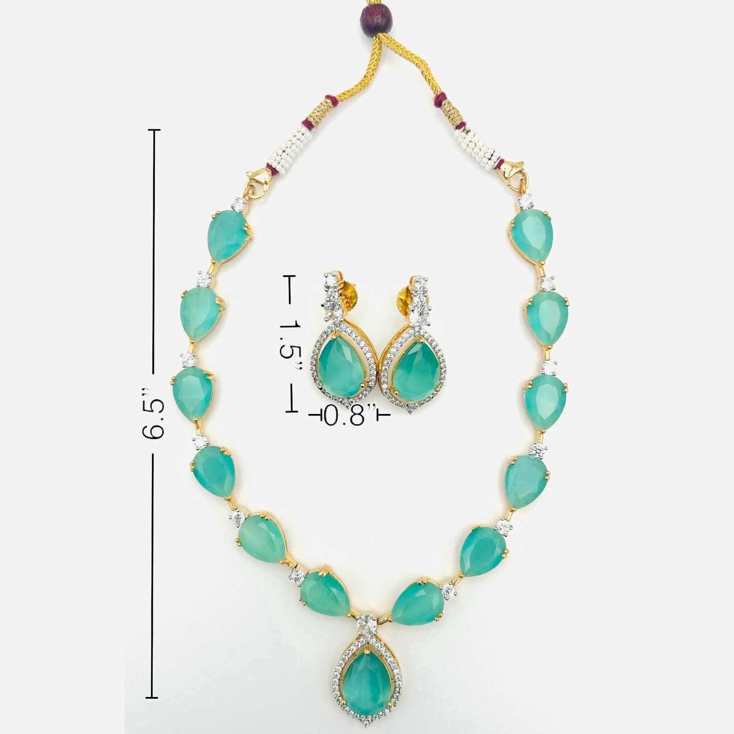 Jewelry set with necklace and earrings featuring green stones on a white background