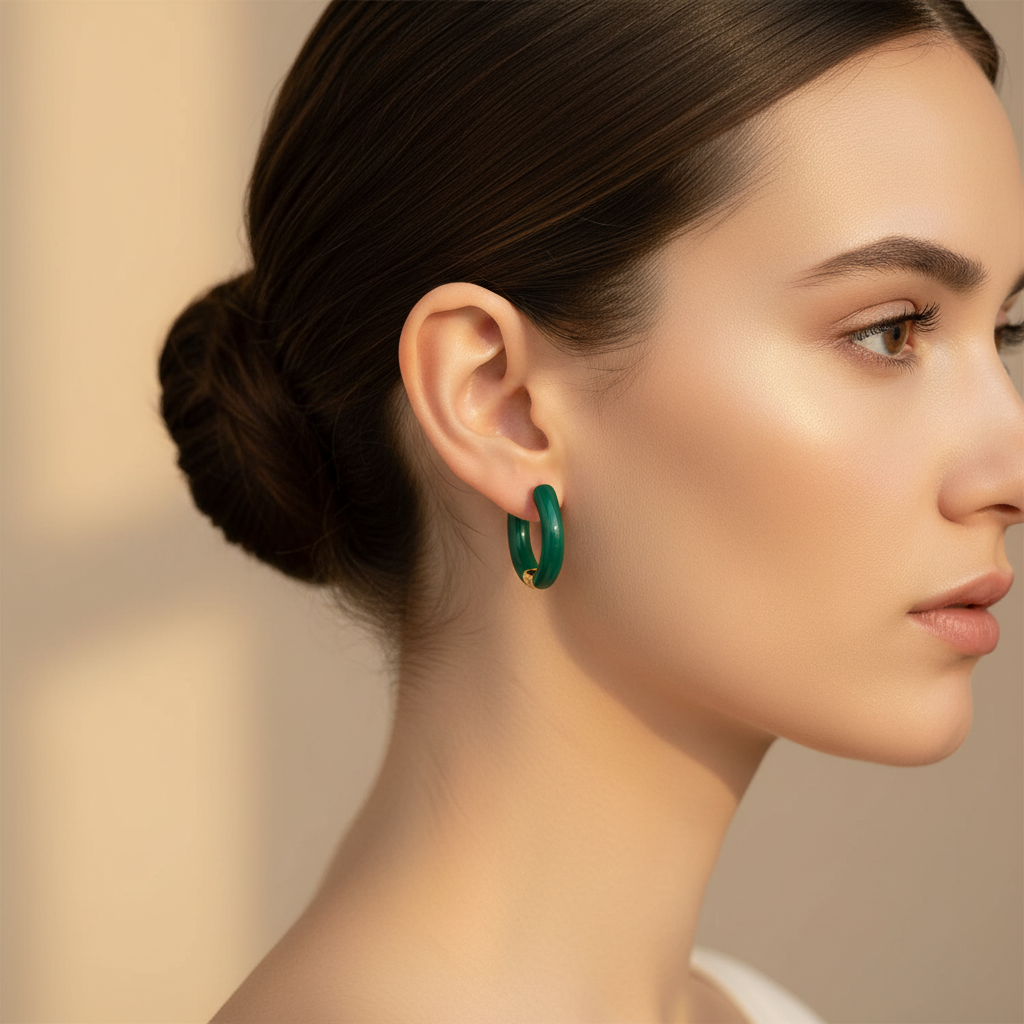 Woman wearing green hoop earrings against a neutral background