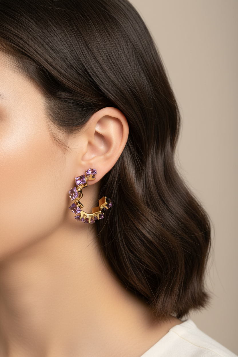 Close-up of a person wearing a pair of earrings with a neutral background