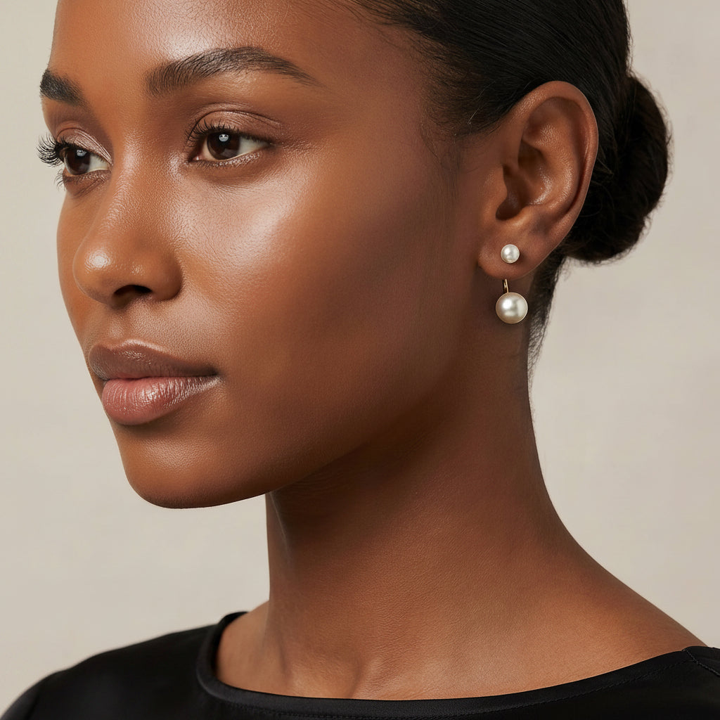 Close-up of a woman wearing pearl earrings against a neutral background