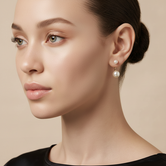 Close-up of a woman wearing pearl earrings against a beige background