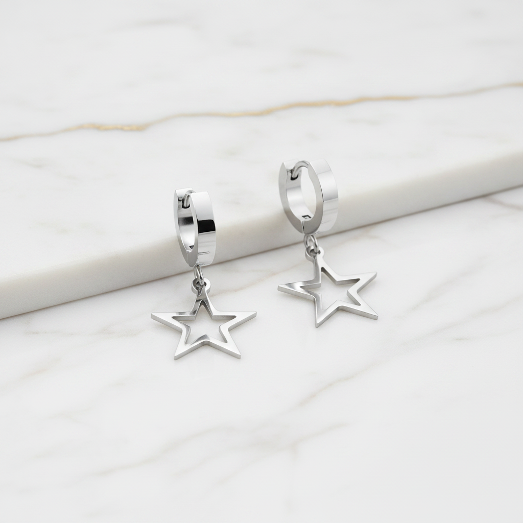 Silver star-shaped earrings on a marble surface