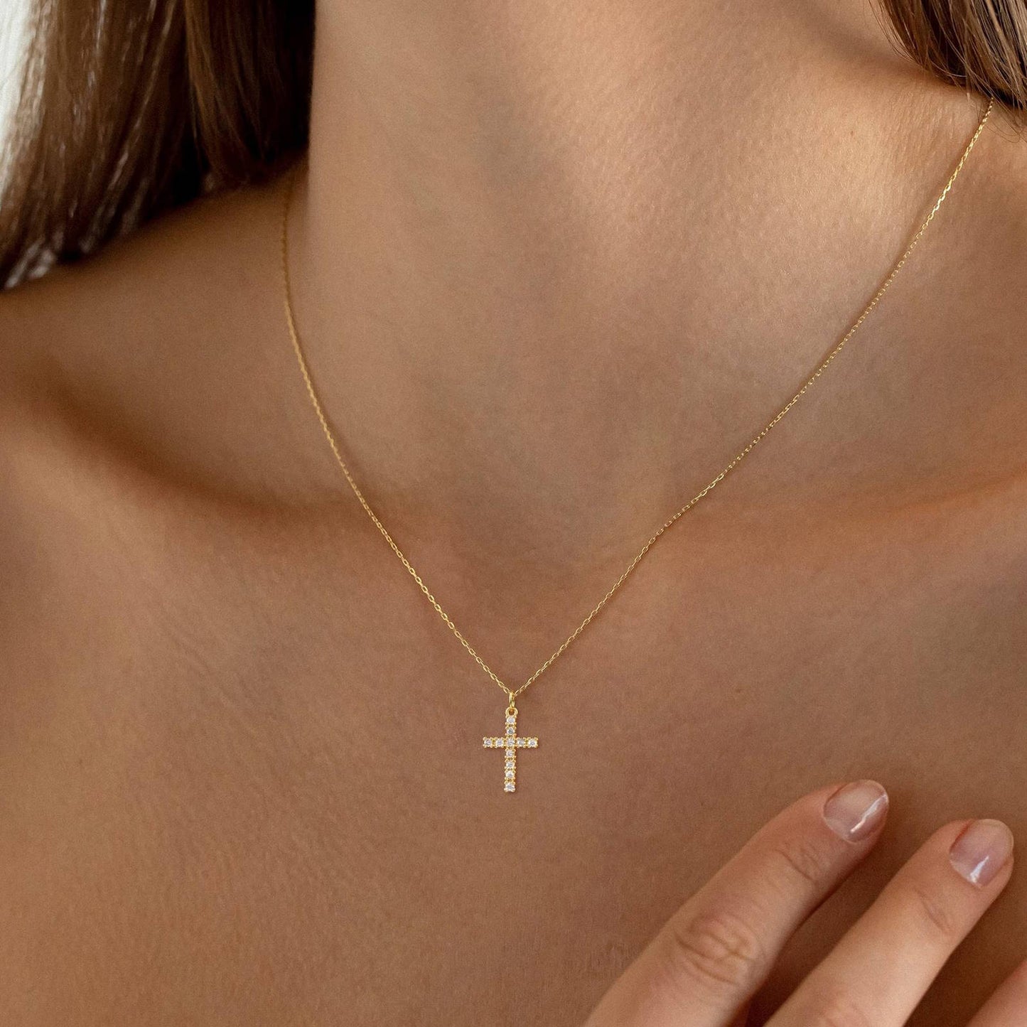 water proof Gold plated  necklace with a cross pendant on a person's neck