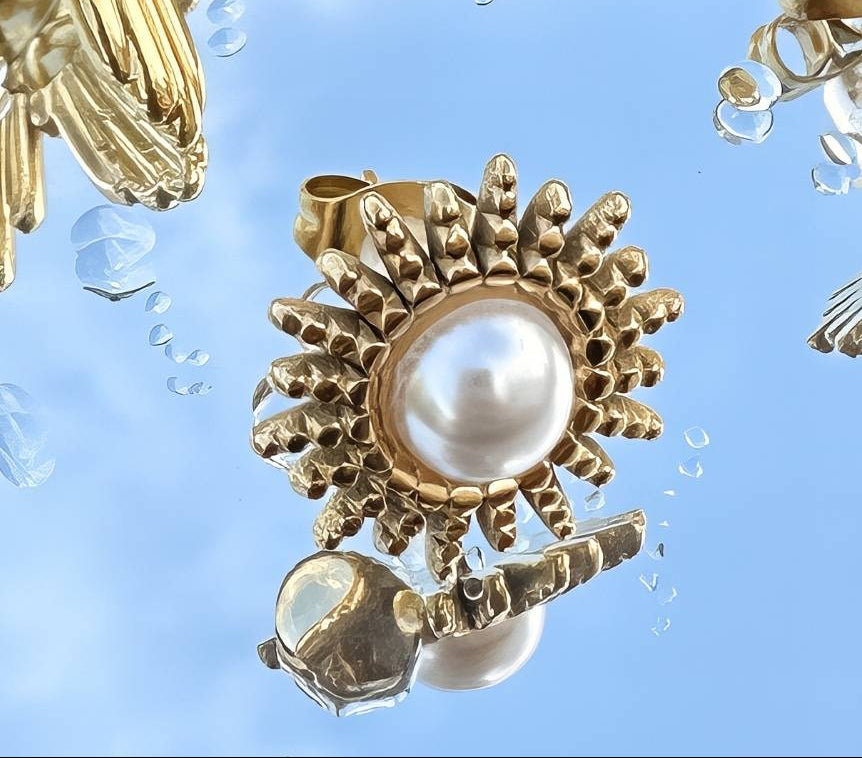 18k Gold plated pearl earrings on a clear surface with water droplets.