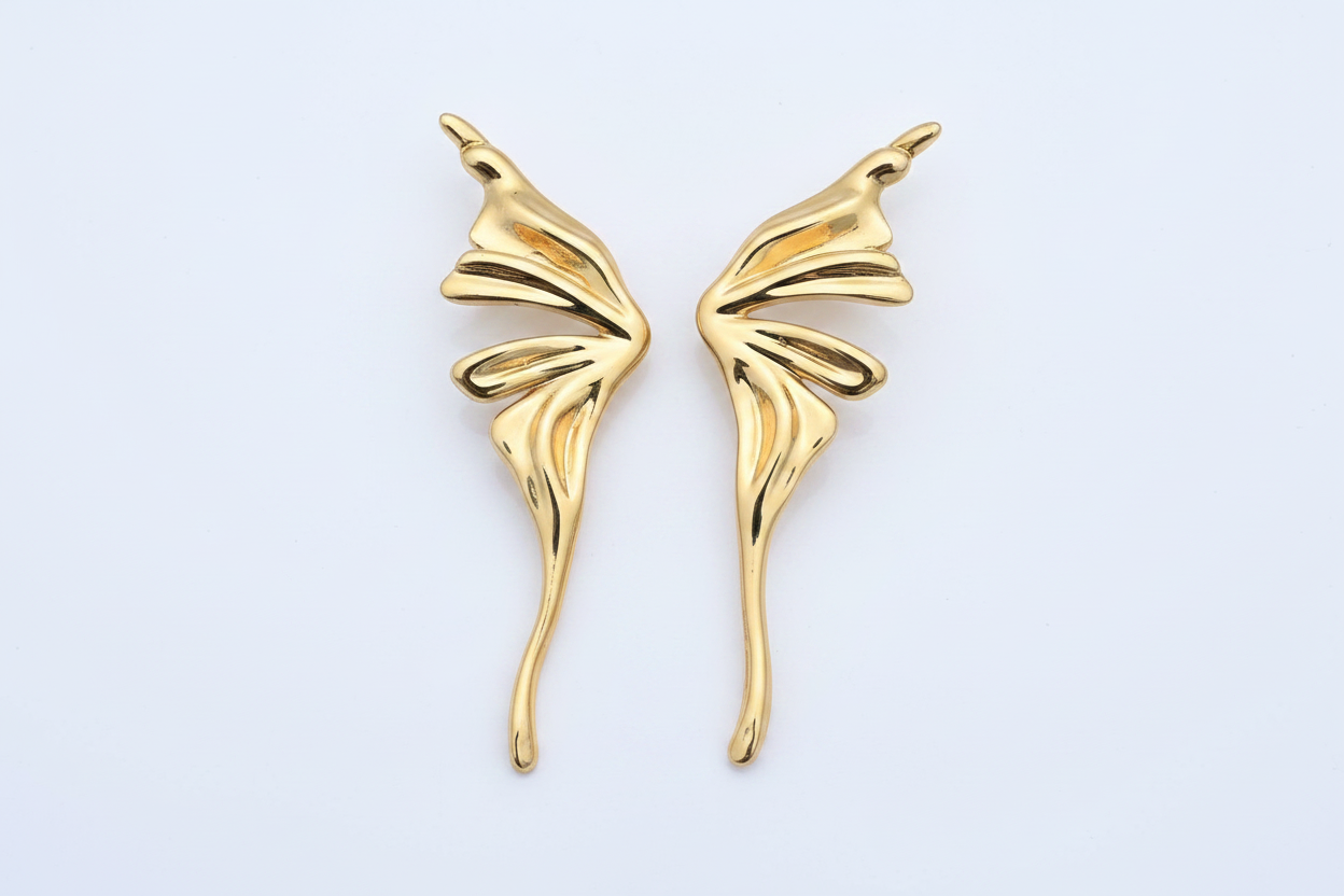 Gold wing-shaped earrings on a light gray background