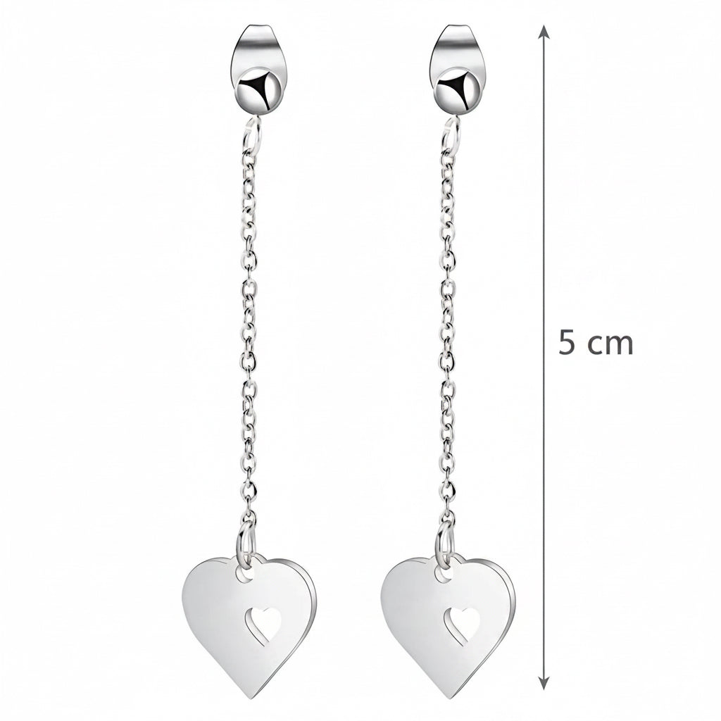 Silver heart-shaped earrings on a beige background