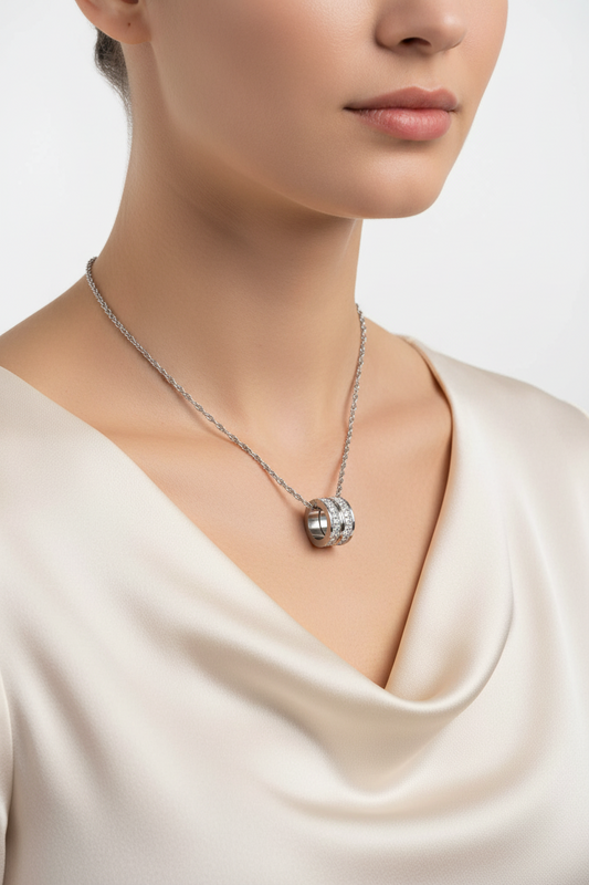 Necklace with a pendant worn by a person in a cream-colored top on a light background