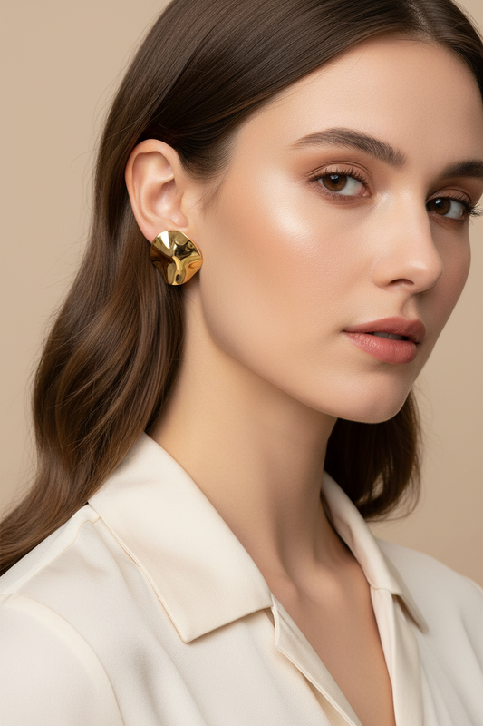 Woman wearing gold earrings with a neutral background
