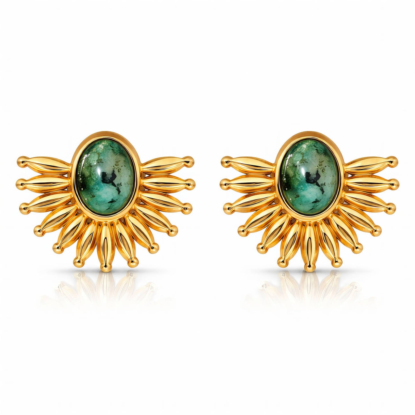 Gold earrings with green gemstones on a white background