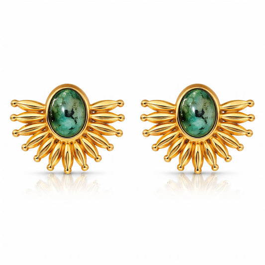Gold earrings with green gemstones on a white background