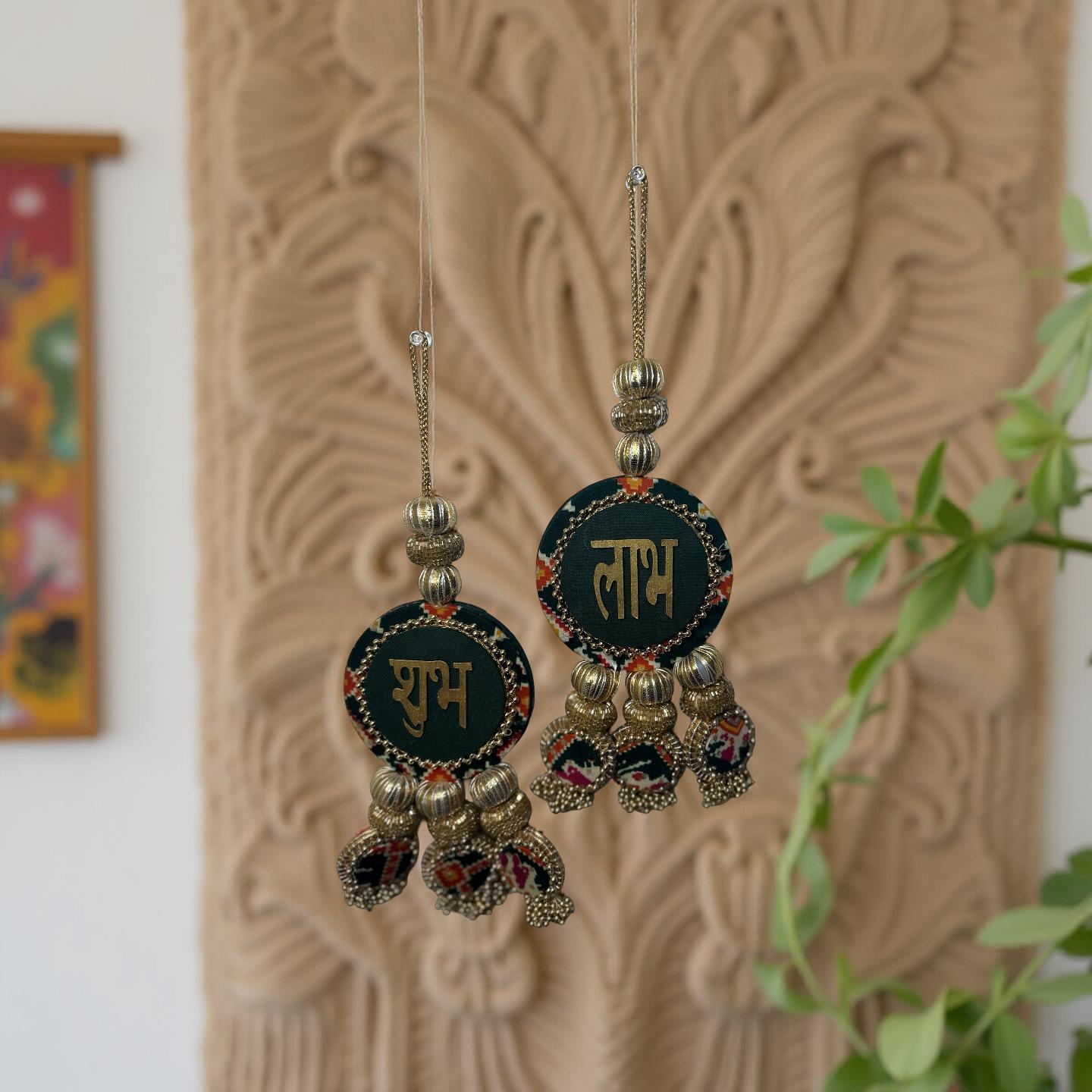 Decorative earrings with intricate designs hanging against a textured wall.