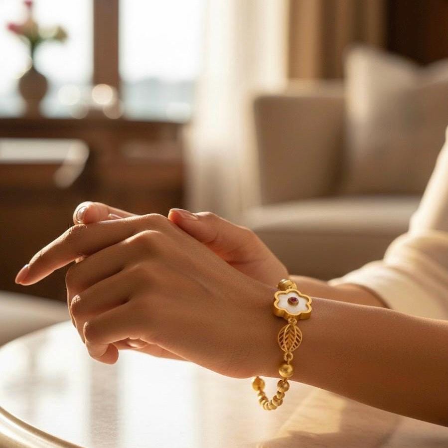 Close-up of a hand wearing a gold bracelet with a blurred indoor background