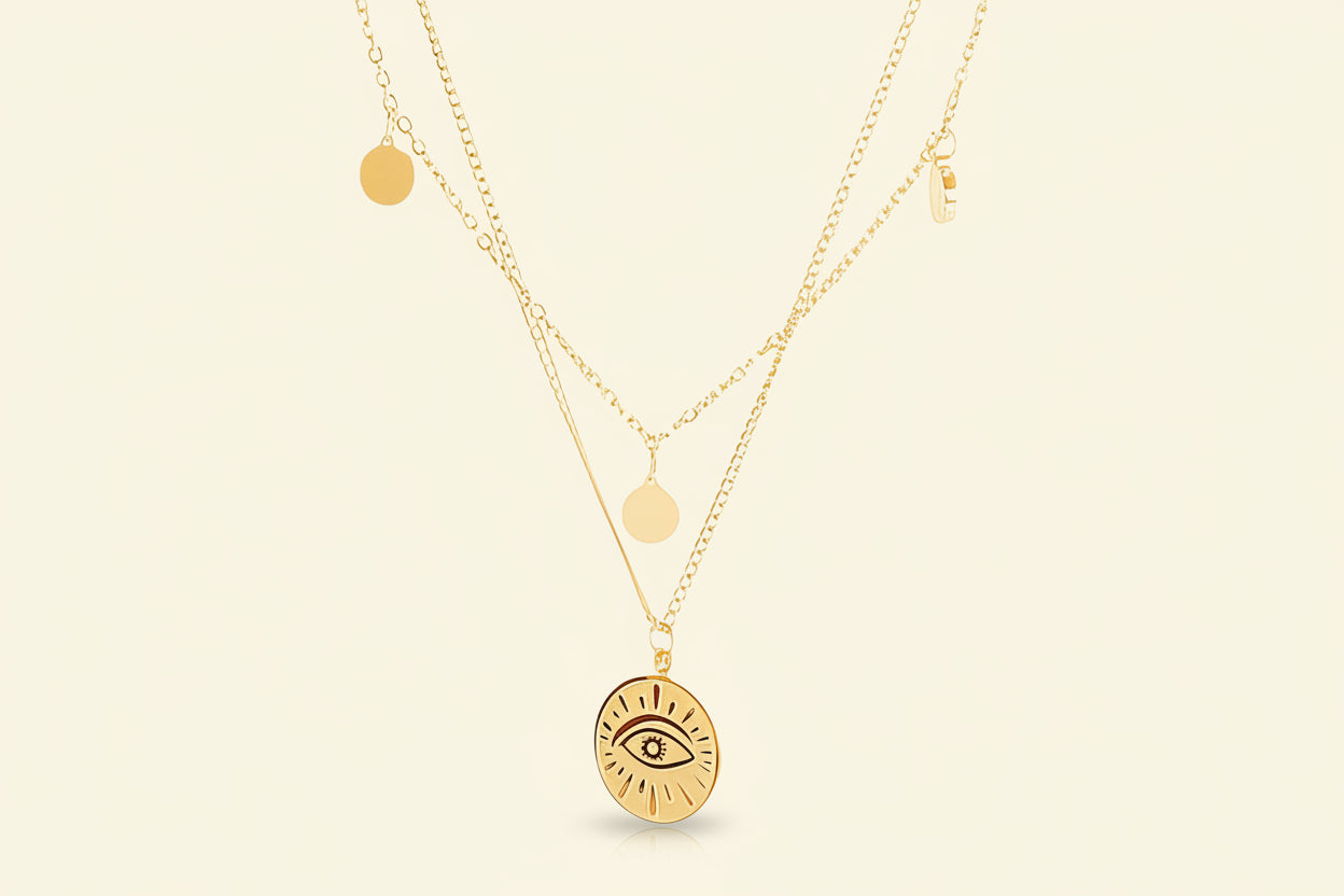 Gold necklace with eye pendant on a white background