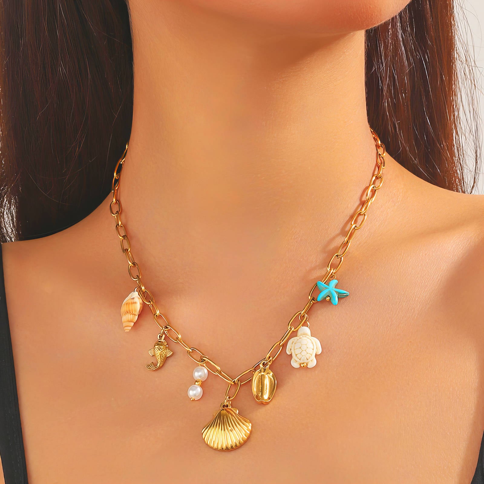 Necklace with various charms including a starfish, turtle, and shell on a model.