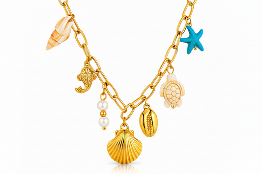 18k Gold necklace with various charms including shells, a starfish, and pear drop on a white background