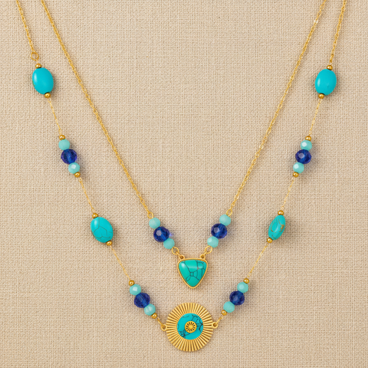Necklace with turquoise and blue beads on a beige fabric background