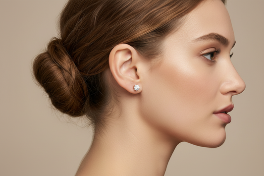 Woman with a styled bun and CZ diamond stud earring on a beige background