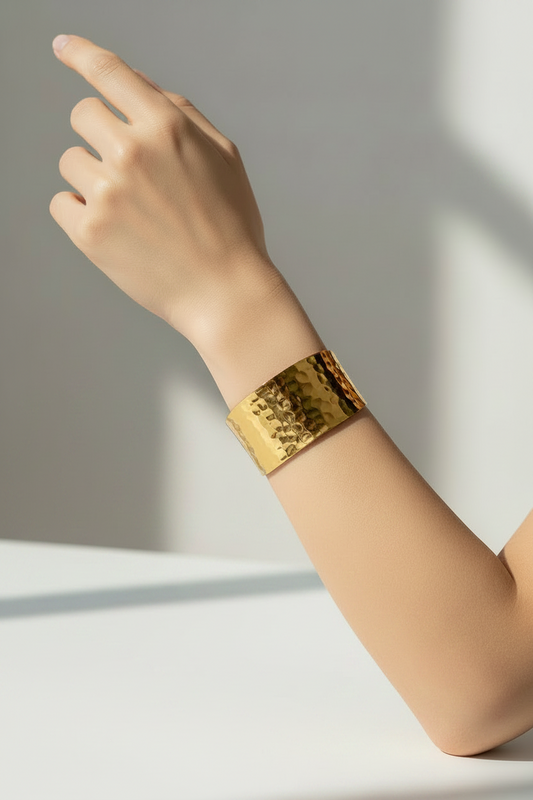 18k Gold plated antique bracelet on a person's wrist with a neutral background