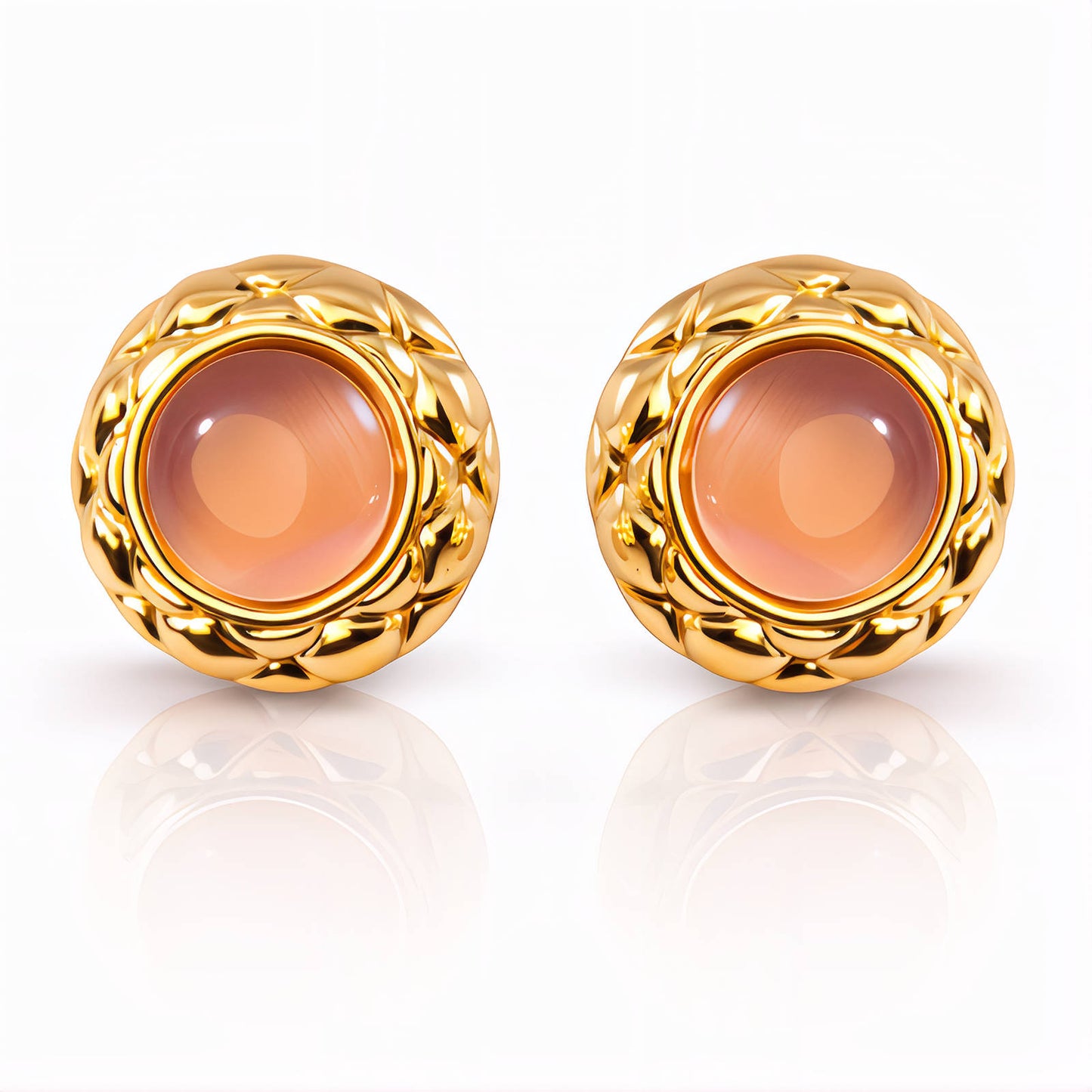 Pair of gold earrings with a central peach-colored gemstone on a white background