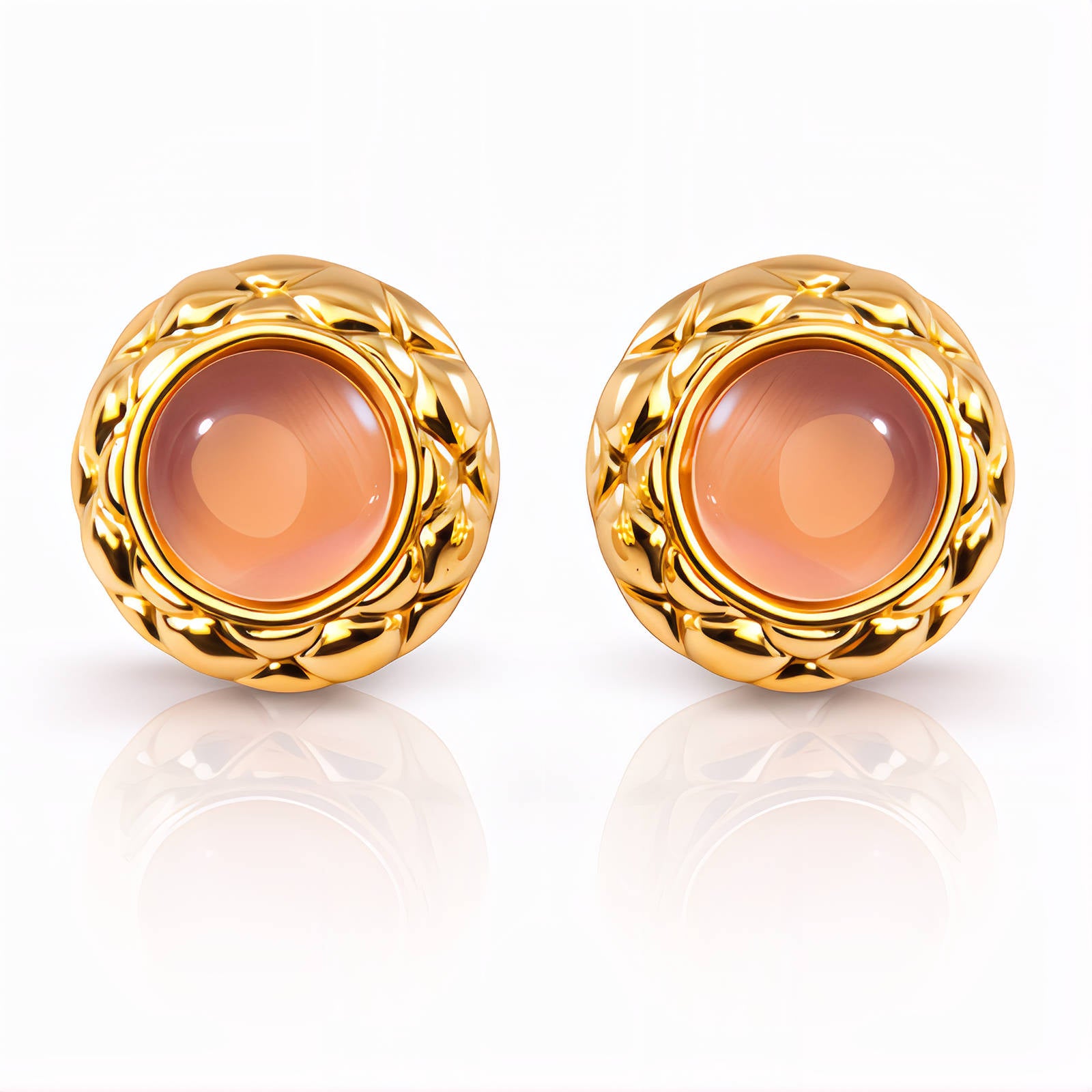 Pair of gold earrings with a central peach-colored gemstone on a white background