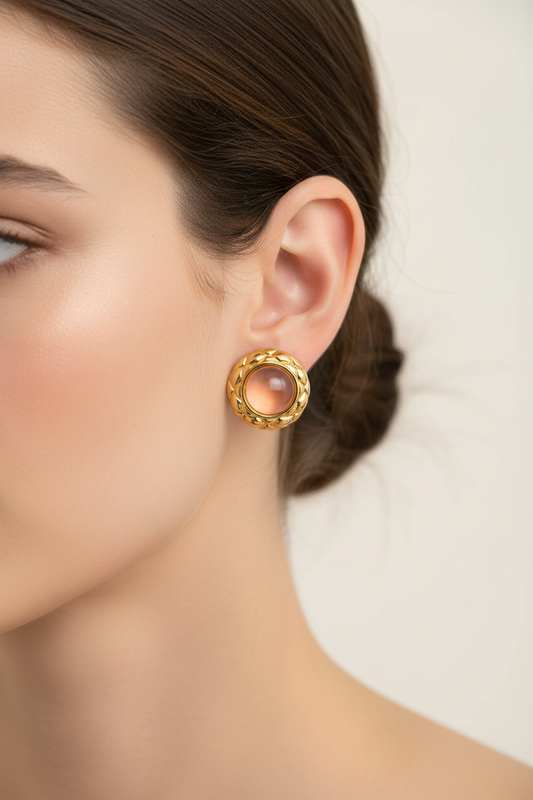 Gold plated pink stone stud earring worn by a person with a neutral background