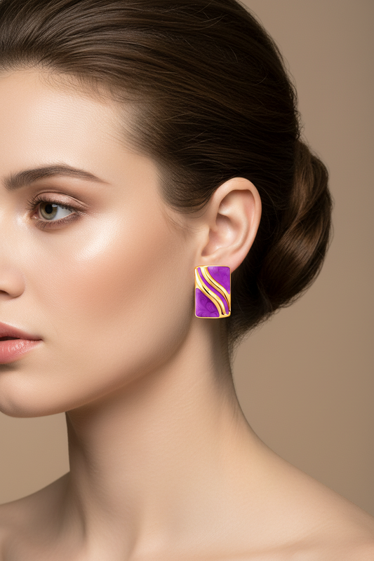 Close-up of a woman wearing a purple earring with gold accents against a neutral background