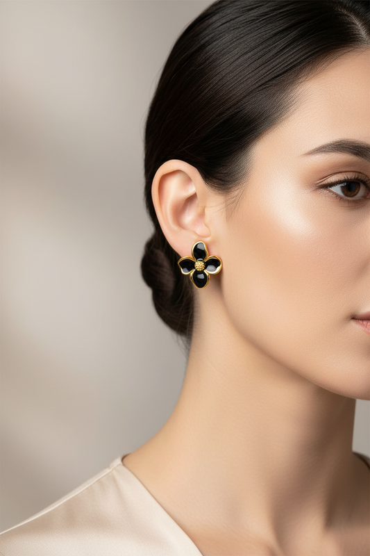 Close-up of a woman wearing a floral black earring with a neutral background