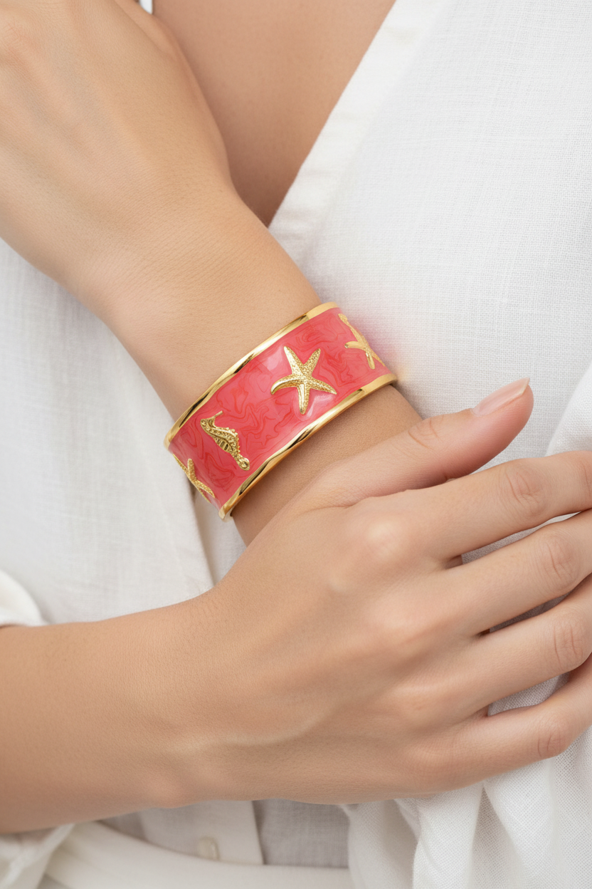 Close-up of a hand wearing a red bracelet with gold accents on a white background