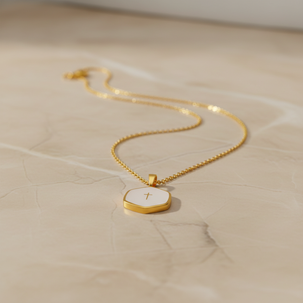 Gold necklace with a pendant on a beige surface