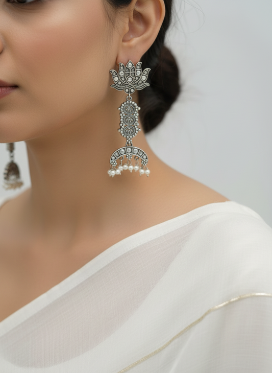 Close-up of a woman wearing lotus silver earrings with a white background