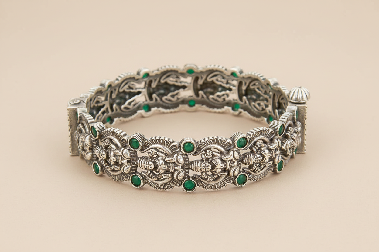 Silver bracelet with green gemstones on a beige background