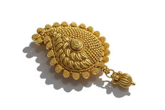 Gold brooch with intricate design on a white background