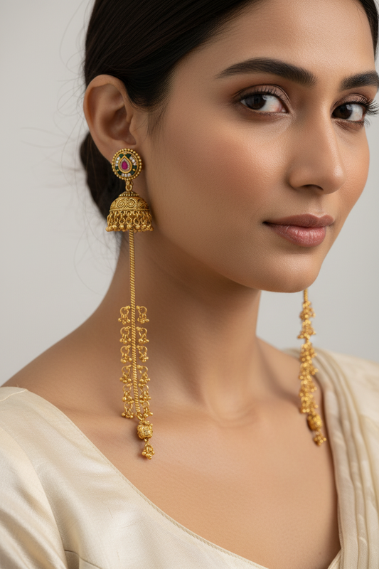 Woman wearing gold earrings with a plain background