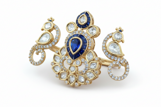 Gold plated kundan ring  with blue gemstone and clear stones on a white background