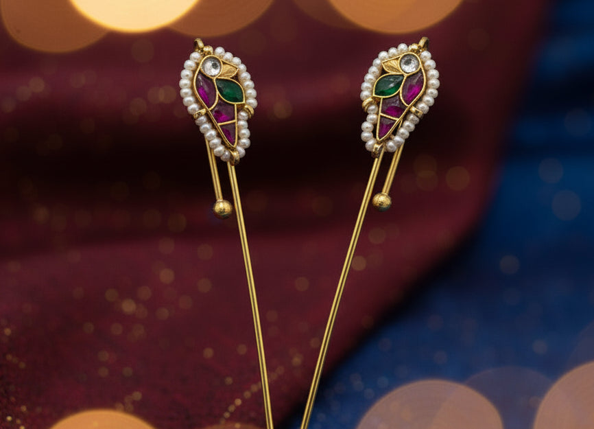 Two gold needle ear cuff earring with gemstones on a light gray background