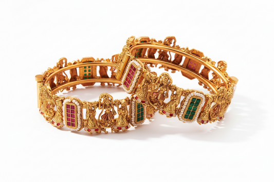 Gold bracelet with intricate designs and colored stones on a white background