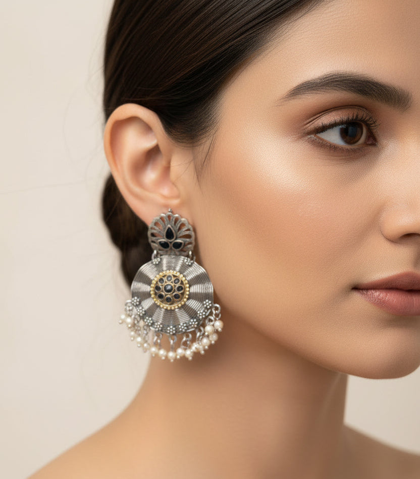 Pair of silver earrings with floral design on a white background