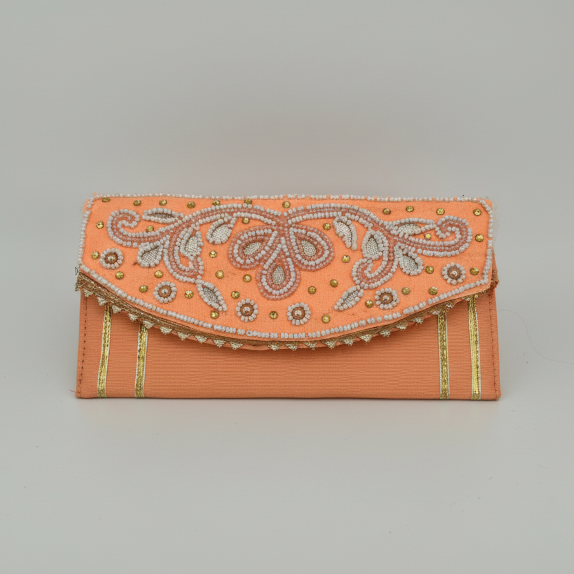 Decorative orange clutch bag with intricate patterns on a gray background